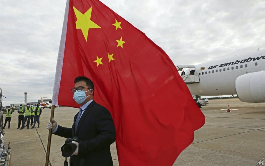 <p>An official from the Chinese embassy in Zimbabwe greeting a plane carrying Sinopharm COVID-19 vaccines from China. Tsvangirayi Mukwazhi/AP</p>